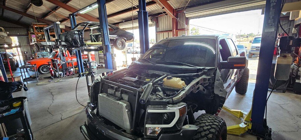 Auto repair shop with vehicles on lifts — JEP Autoworks Hemet CA